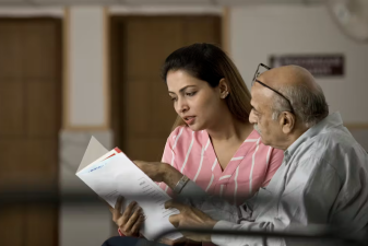 An image of a man and a woman looking at folder.